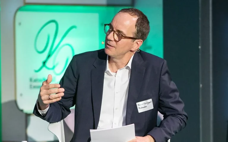 Moderation beim AOK Forum live Marcel Weigand, auf Bühne moderierend