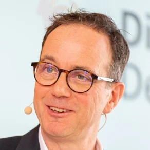 Marcel Weigand moderiert auf einer Bühne.